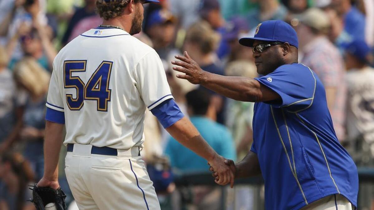 
Seattle Mariners reliever Tom Wilhelmsen (54) is congratulated by manager Lloyd McClendon after the 8-6 win over the Chicago White Sox on Sunday.

