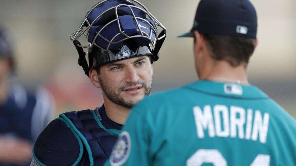 Seattle Mariners catcher Mike Zunino, left, talks with relief pitcher Mike Morin during a baseball spring training workout, Monday, Feb. 19, 2018, in Peoria, Ariz.