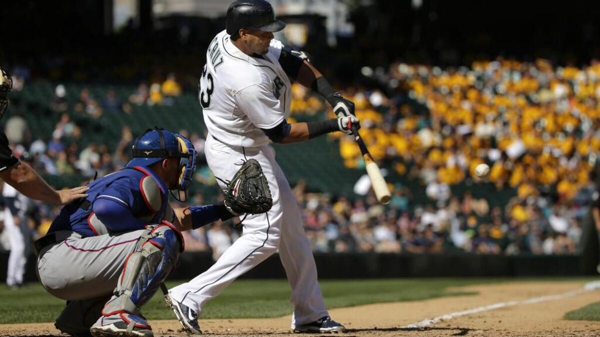 
Seattle’s Nelson Cruz,, in his return after sitting out six games because of a strained right hamstring, hits a two-run home run in the seventh inning against the Texas Rangers at Safeco Field on Thursday.
