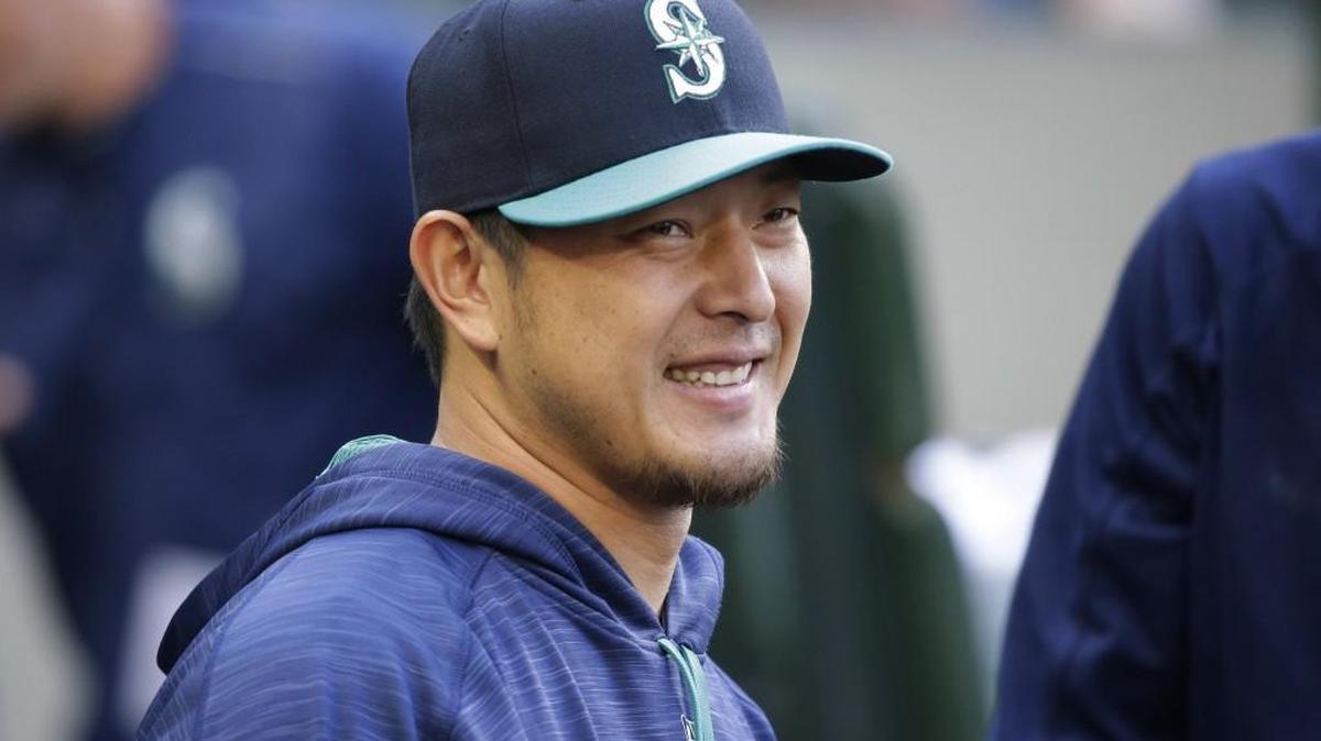 Seattle Mariners pitcher Hisashi Iwakuma smiles as he greets teammates in the dugout before the team's baseball game against the Oakland Athletics, Friday, July 7, 2017, in Seattle.