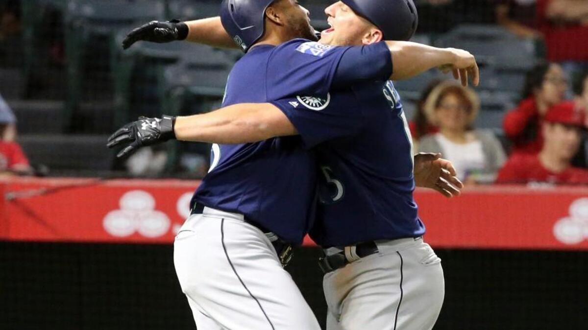 Kyle Seager (right) got an embrace from Nelson Cruz after hitting a three-run homer in the eighth inning.