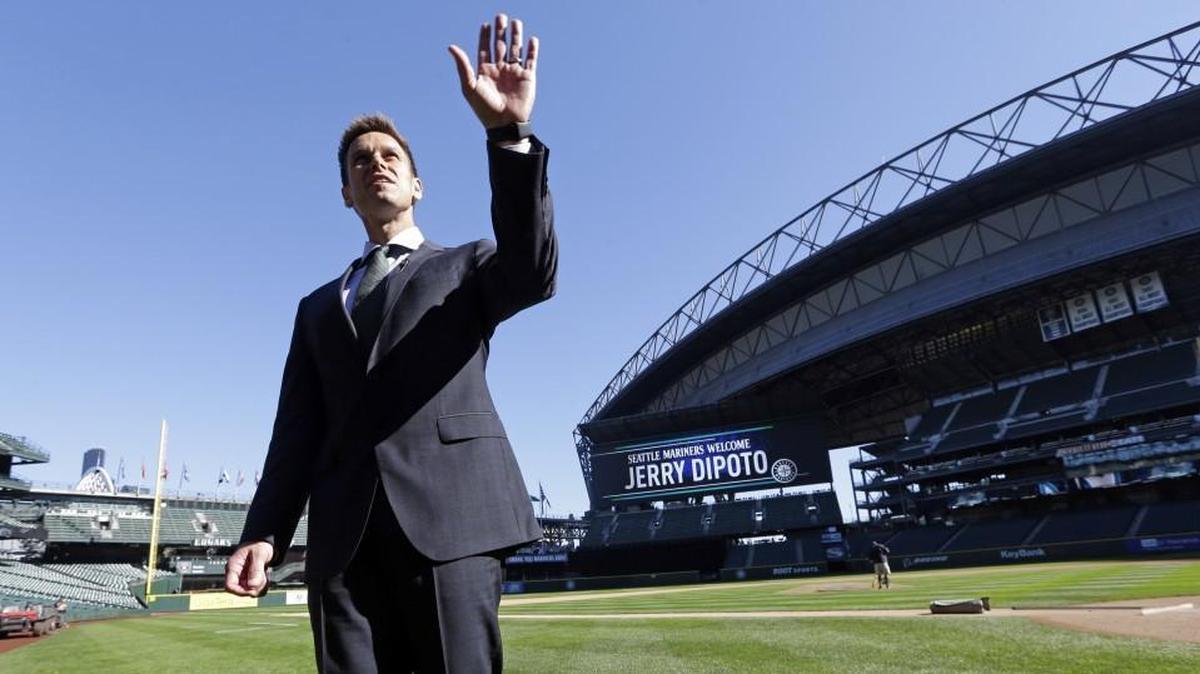 
New Seattle Mariners general manager Jerry Dipoto motions toward the upper deck of the team’s ballpark as he stands on the field after a news conference Tuesday in Seattle. For Dipoto, being hired by the Mariners as their new GM comes with one task above all others: ending the longest postseason drought in baseball. 
