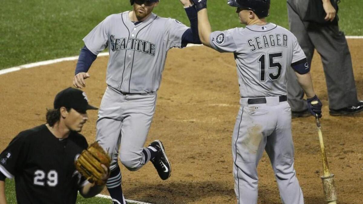 
Seattle’s Brad Miller, left, celebrates with Kyle Seager after scoring on a sacrifice fly by Ketel Marte off Chicago White Sox starter Jeff Samardzija (29) during the fourth inning of the Mariners victory Saturday in Chicago.
