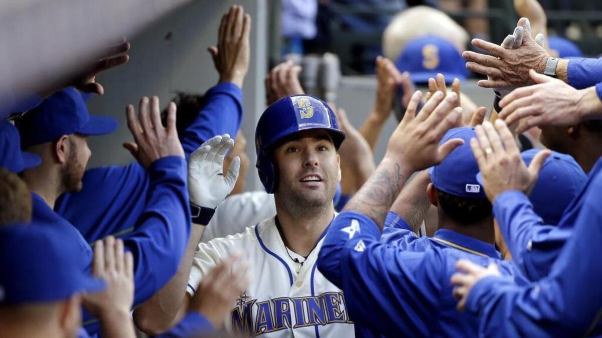 Seattle Mariners' Seth Smith is greeted in the dugout after his three-run home run against the Houston Astros in the fourth inning of a baseball game Sunday, Sept. 18, 2016, in Seattle.