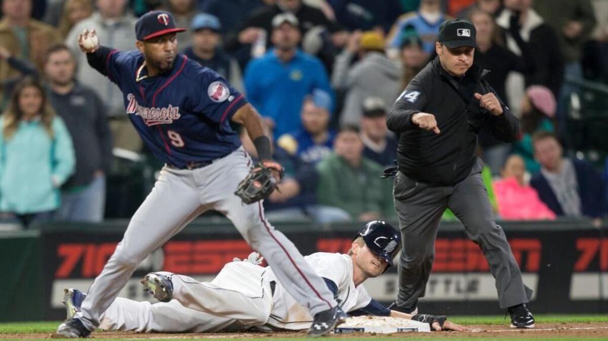 Seattle Mariners' Shawn O'Malley lays on the ground after being tagged out caught stealing by Minnesota Twins third baseman Eduardo Nunez who threw to second to complete a double play in the ninth inning of a baseball game, on Saturday, May 28, 2016, in Seattle. The Twins won 6-5.