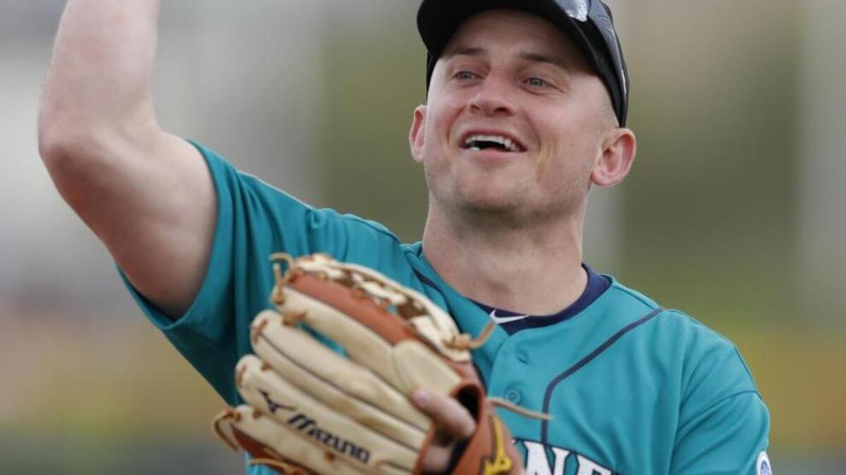 Seattle Mariners third baseman Kyle Seager throws a baseball to fan in the stands during the third inning of a spring training baseball game against the San Diego Padres, Friday, Feb. 23, 2018, in Peoria, Ariz.