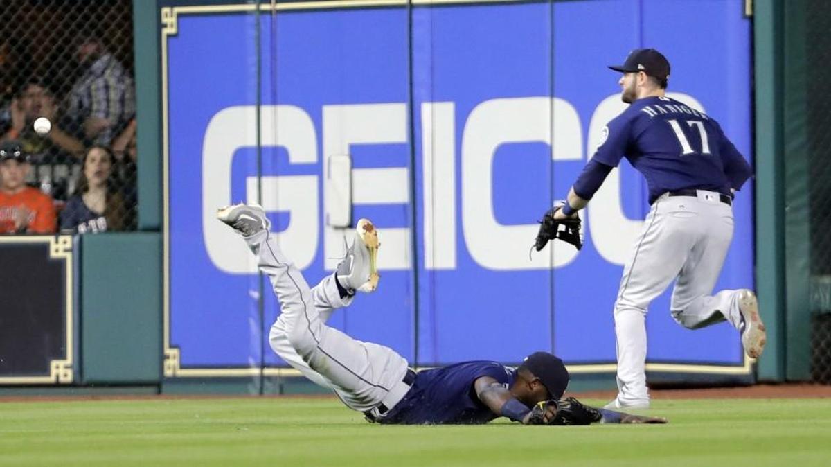 Seattle Mariners center fielder Guillermo Heredia, left, falls after trying to make a diving catch on a double by Houston Astros' George Springer as right fielder Mitch Haniger (17) chases after the ball during the fourth inning of a baseball game Saturday, Sept. 16, 2017, in Houston. (AP Photo/David J. Phillip)