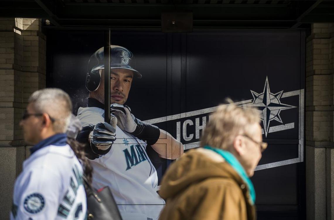 Fans walk by an Ichiro Suzuki poster outside of Safeco Field. The Seattle Mariners played the Cleveland Indians in a baseball game on Opening Day at Safeco Field in Seattle, Wash., on Thursday, March 29, 2018.