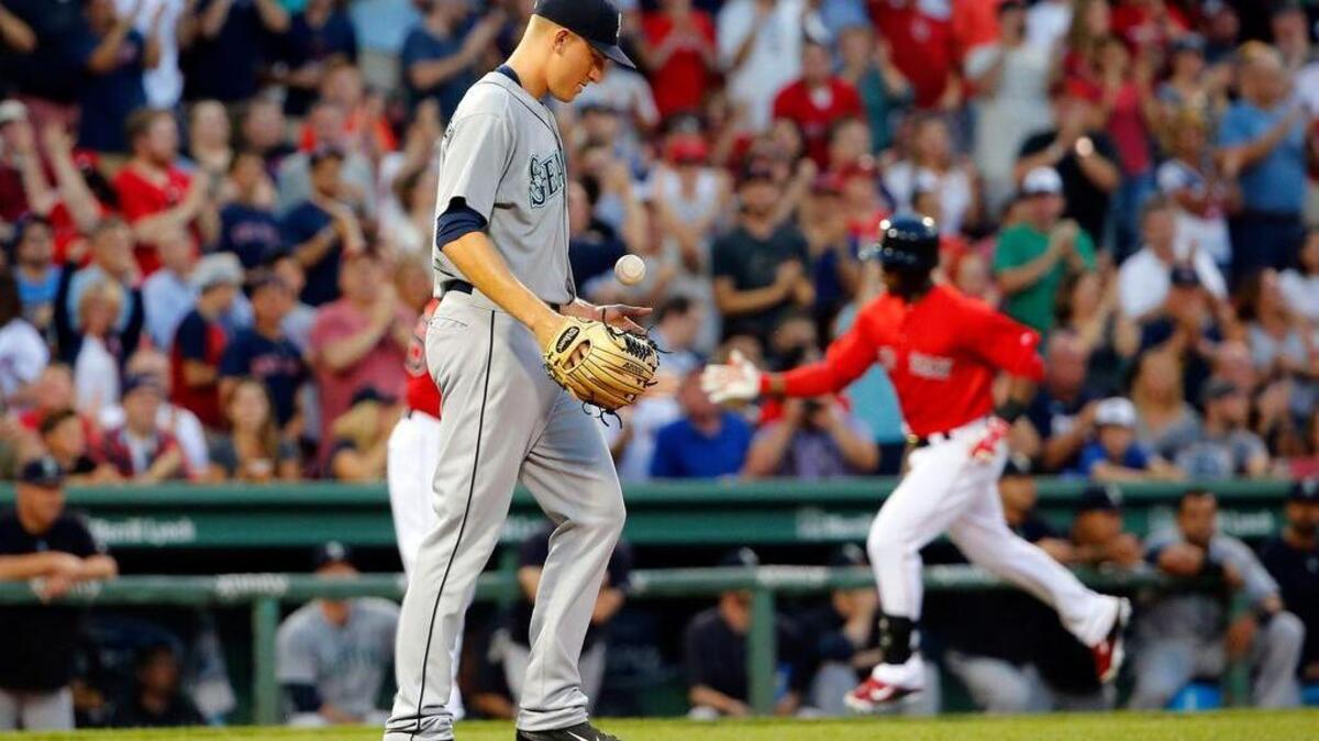 
Seattle Mariners starting pitcher Mike Montgomery tosses a new ball in the air as Boston Red Sox's Rusney Castillo, right, rounds the bases after his two-run home run during the first inning of a baseball game at Fenway Park in Boston Friday, Aug. 14, 2015.
