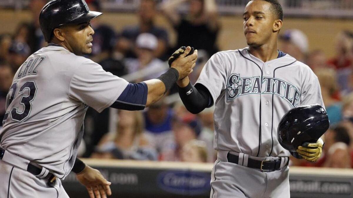 
Rookie Ketel Marte, right, congratulates Nelson Cruz after they scored on Cruz’s two-run home run Friday. Marte walked in five plate appearances in his major league debut. 
