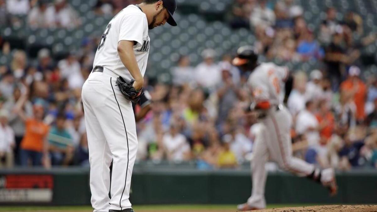 
Mariners starting pitcher Vidal Nuno kicks at the mound as the Orioles' Adam Jones circles the bases after blasting a first-inning home run Monday at Safeco Field.

