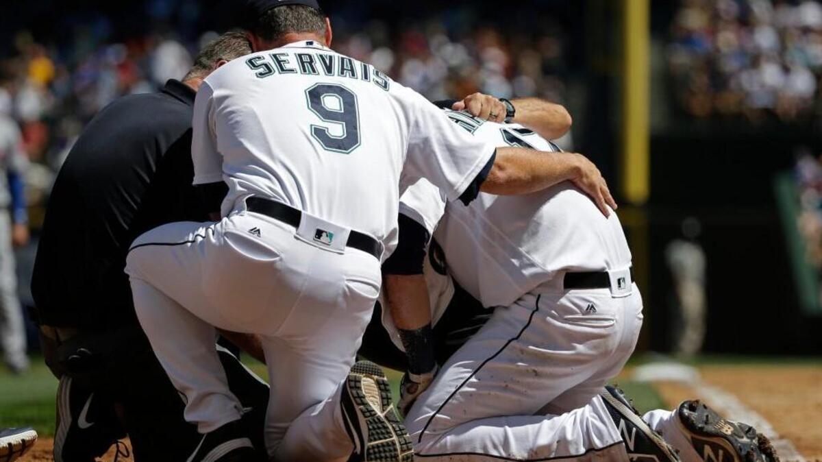 Mitch Haniger gets assistance from manager Scott Servias after being hit in the face by a pitch.