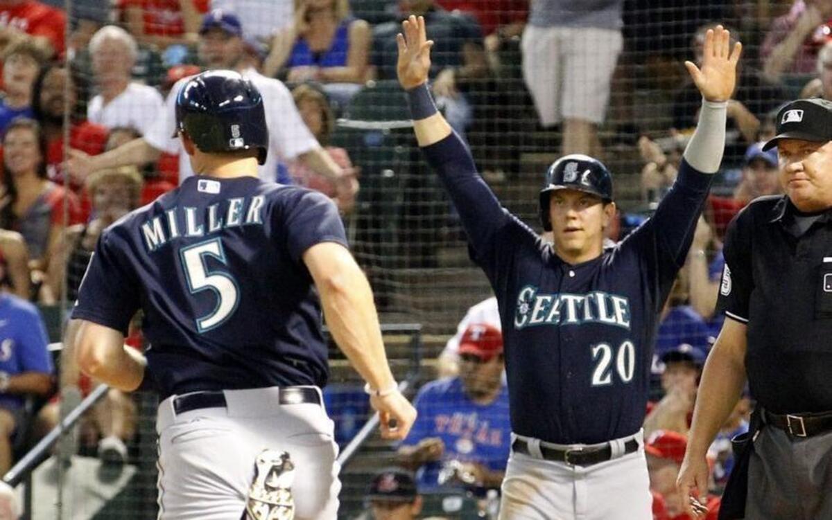 Seattle Mariners shortstop Brad Miller (5) and Logan Morrison (20) score in the second inning against the Texas Rangers in Arlington, Texas, in September. The two were traded Thursday along with Danny Farquhar to Tampa Bay.