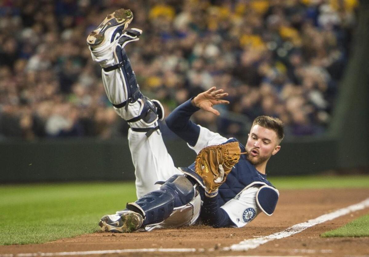 Catcher Mike Marjama falls over making a catch in the fifth inning. The Seattle Mariners played the Cleveland Indians in a baseball game on Opening Day at Safeco Field in Seattle, Wash., on on Thursday, March 29, 2018.