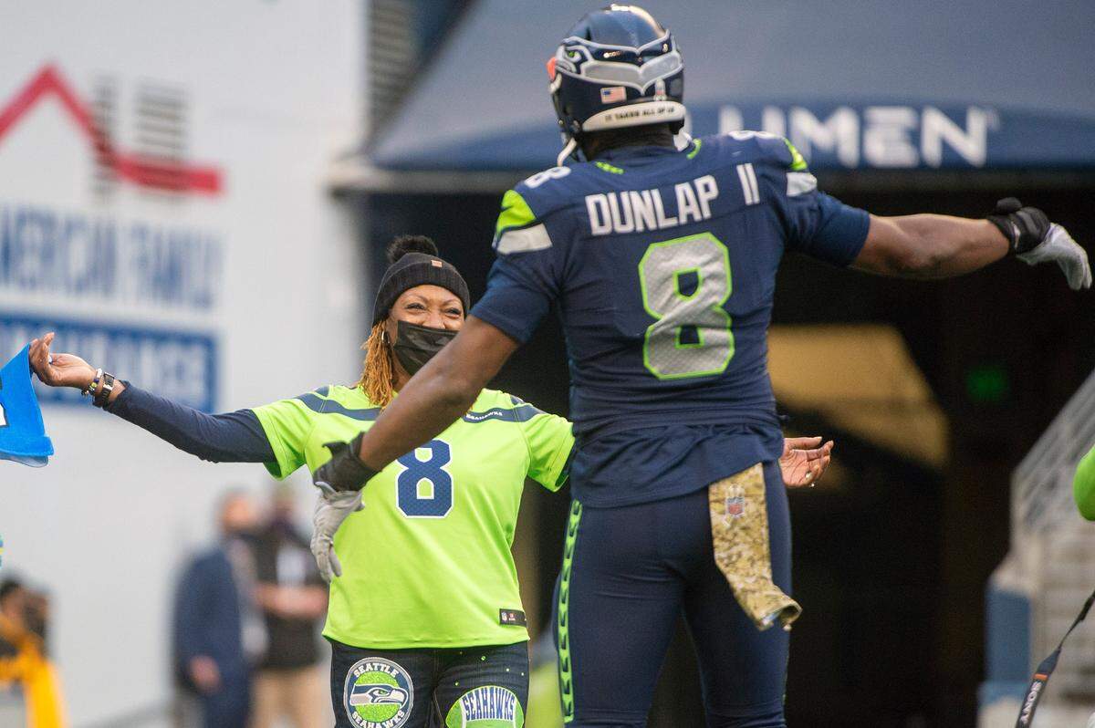 Seahawks defensive end Carlos Dunlap hugs his mother, 11-year U.S. Army Reserve dental specialist Dr. Diana-Ross Jackson, during the third quarter of Seattle’s game against the Arizona Cardinals at Lumen Field Sunday, Nov. 21, 2021. It was the Seahawks’ annual Salute to Service game.