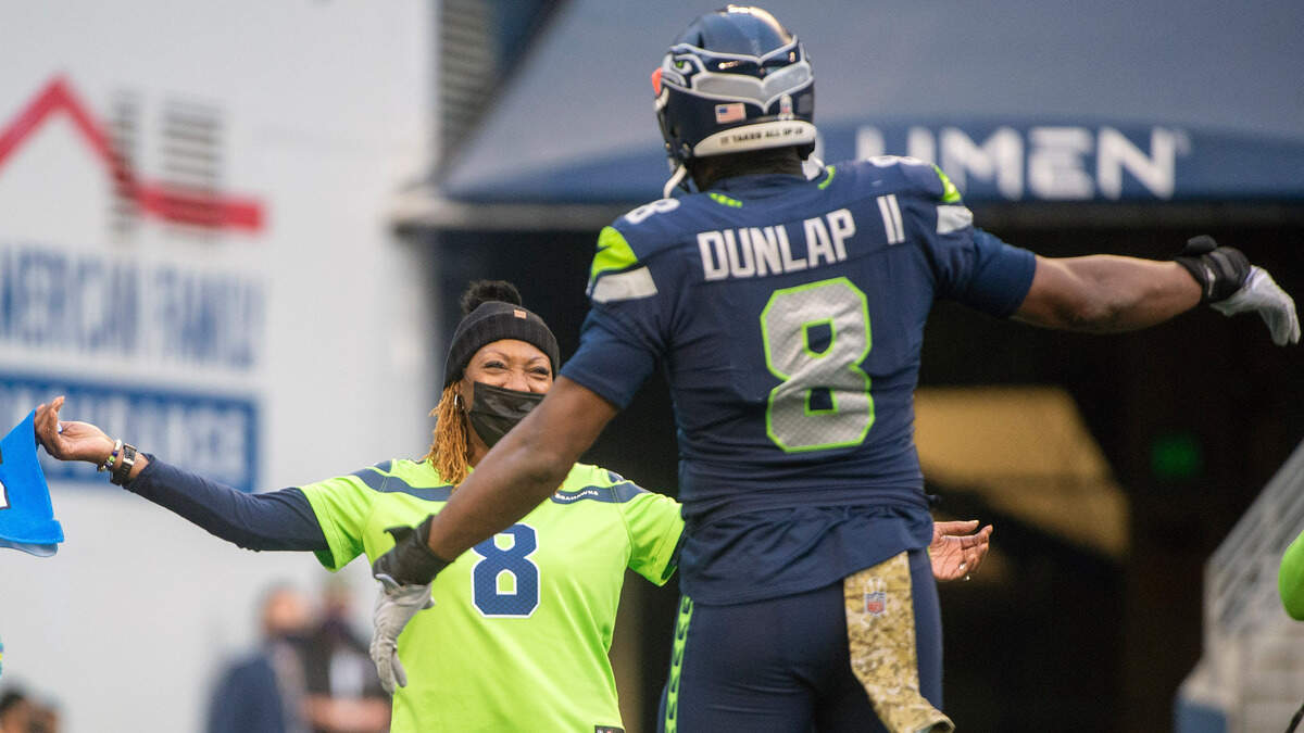 Seahawks defensive end Carlos Dunlap hugs his mother, 11-year U.S. Army Reserve dental specialist Dr. Diana-Ross Jackson, during the third quarter of Seattle’s game against the Arizona Cardinals at Lumen Field Sunday, Nov. 21, 2021. It was the Seahawks’ annual Salute to Service game.