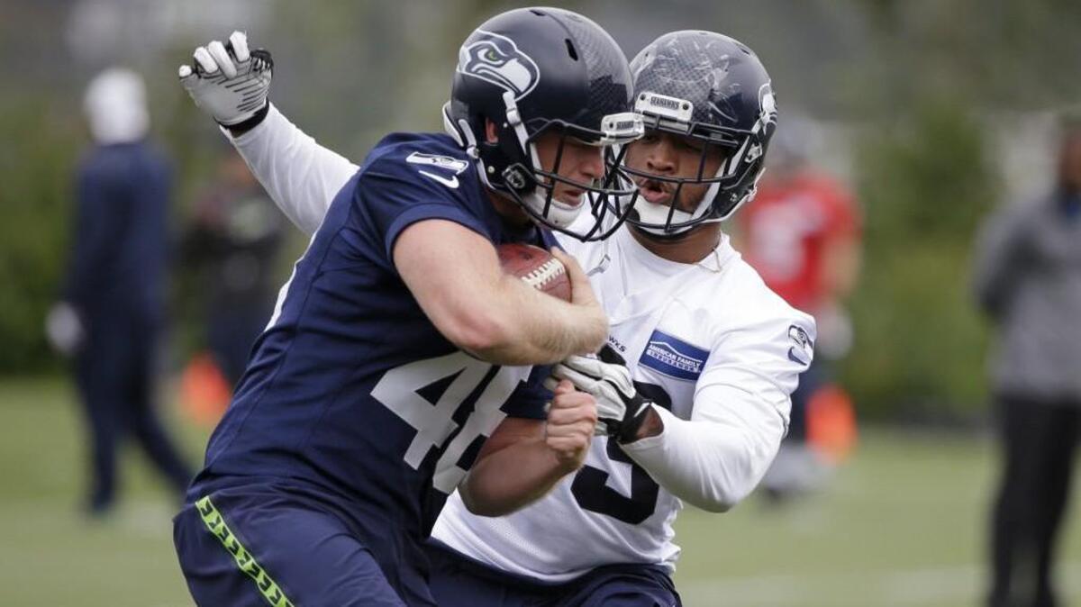 Seattle’s Nolan Frese, left, moves toward Drew Ferris during a drill at the team's NFL football training camp on July 30 in Renton.