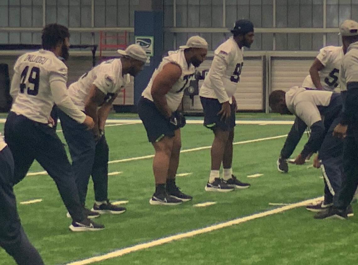 Matt Gotel from Tacoma and Lakes High School (third from left, sleeves pushed up) lines up with fellow defensive linemen during a walk-through practice on the final day of Seahawks rookie minicamp May 8, 2022, at the team’s Virginia Mason Athletic Center in Renton.