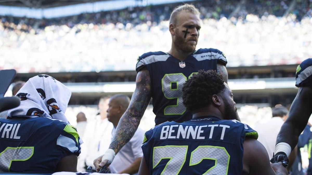 Then-Seahawks defensive end Cassius Marsh shakes hands with fellow pass rushers Cliff Avril and Michael Bennett before the start of a preseason game in Seattle in August 2017. On Thursday the Seahawks re-signed Marsh, after having traded him to New England in 2017. Marsh played for San Francisco last year.