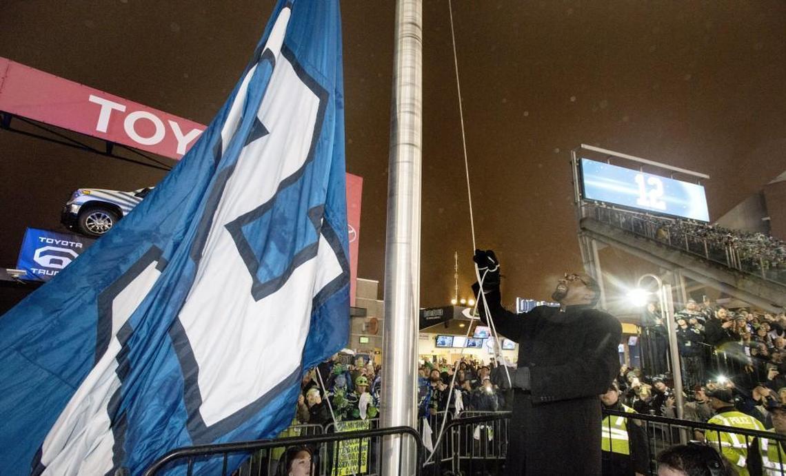Kenny Easley raises the 12th Man flag before the Divisional Playoff game against the Panthers at CenturyLink Field in Seattle on Saturday, Jan. 10, 2015.
