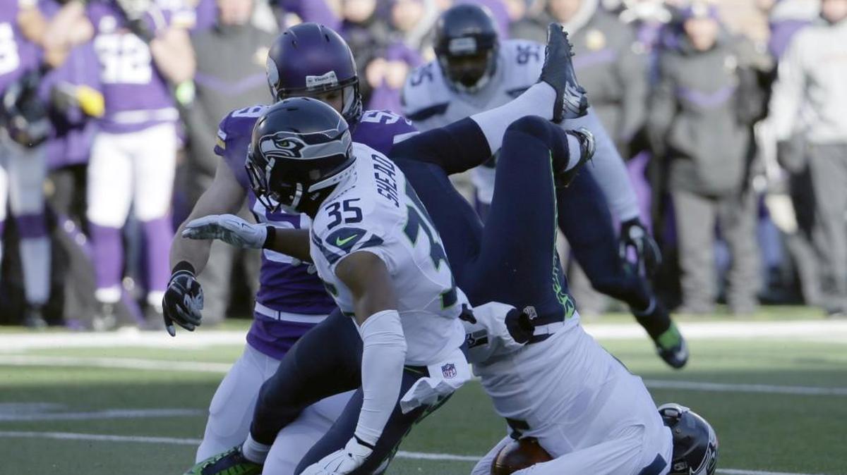 Seattle Seahawks punter Jon Ryan (9) lands on his head after jumping over Minnesota Vikings linebacker Casey Matthews (59) as he runs the ball during the first half of an NFL wild-card football game against the Minnesota Vikings, Sunday, Jan. 10, 2016, in Minneapolis. (AP Photo/Nam Y. Huh)