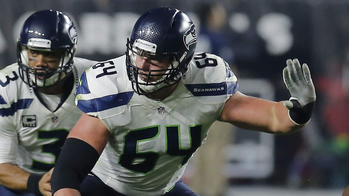 Seahawks guard J.R. Sweezy (64), shown here during the 2014 season blocking for Russell Wilson during a game at the Arizona Cardinals, is expected to start Sunday in Seattle’s season opener at right guard a month after rejoining the team.
