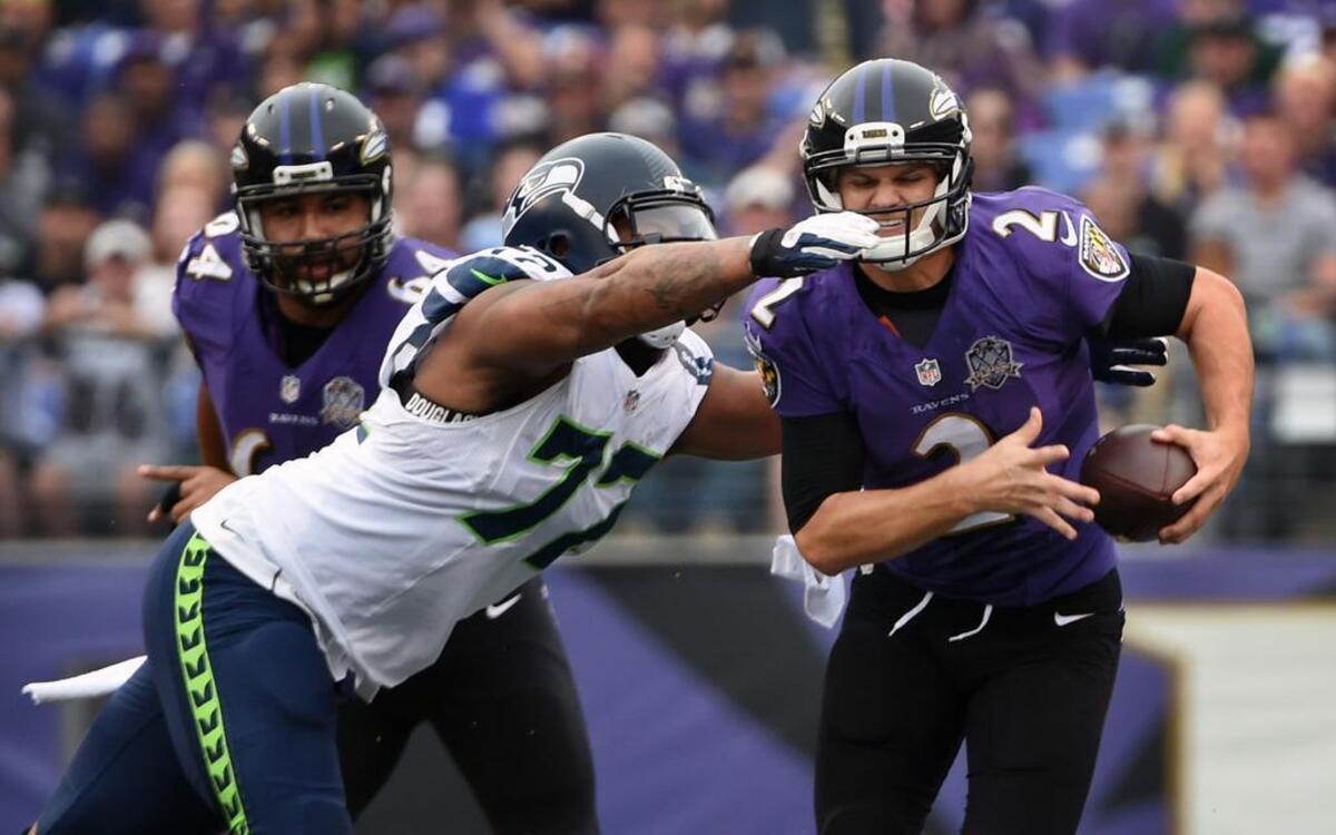 Seattle’s Michael Bennett closes in on Baltimore quarterback Jimmy Clausen in the first quarter. Bennett finished with four tackles, three solo, and one sack.