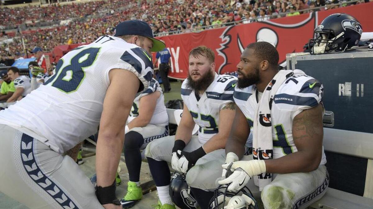 Seattle Seahawks center Justin Britt, left, talks with offensive guard Mark Glowinski, center, and offensive tackle George Fant on the bench during the first half against Tampa Bay this past Sunday. Britt returns to center against the Carolina Panthers on Sunday night.