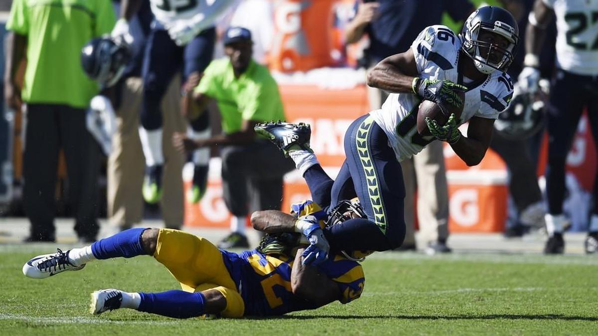 Seattle Seahawks wide receiver Tyler Lockett (16) falls to the ground as he is tackled by Los Angeles Rams cornerback Troy Hill (32) during the second half of an NFL football game at the Los Angeles Memorial Coliseum, Sunday, Sept. 18, 2016, in Los Angeles.