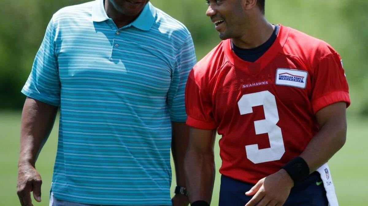 Seattle quarterback Russell Wilson, right, walks off the field with Warren Moon on Friday following practice in Renton.