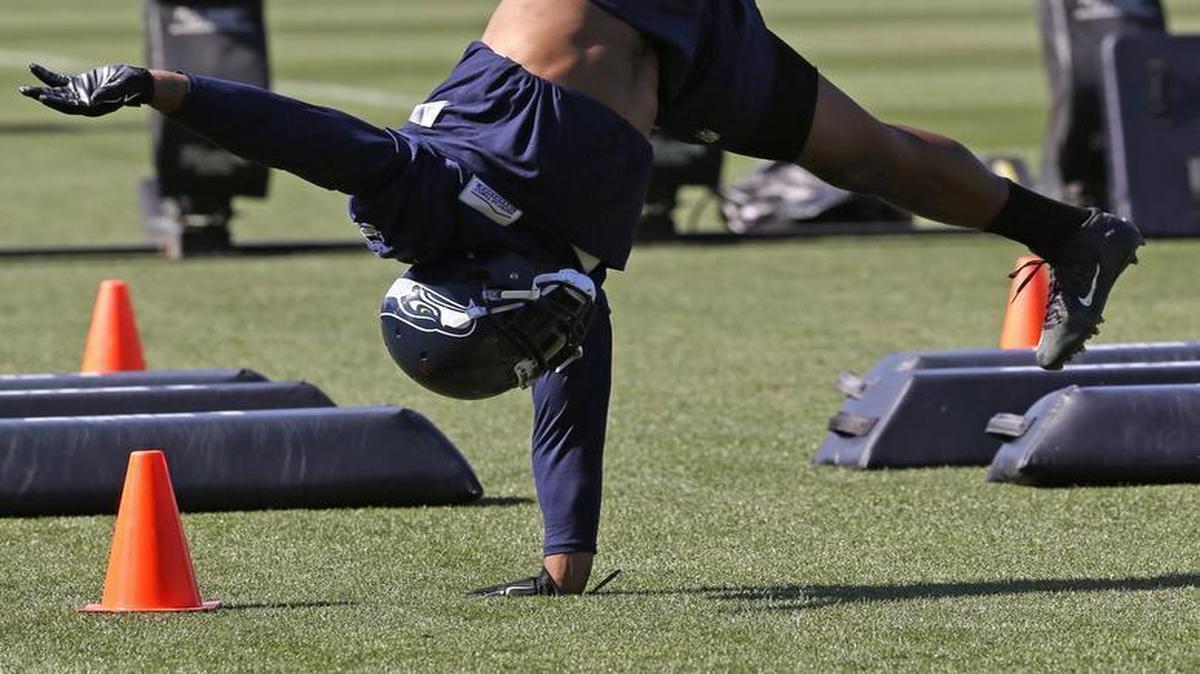 
Seahawks linebacker Bobby Wagner pushes off of one arms as he completes a handstand between drills during the final day of training camp Wednesday at team headquarters in Renton.
