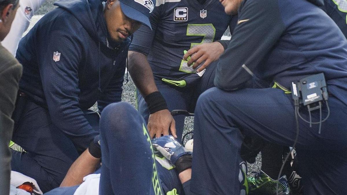 Seahawks coach Pete Carroll and teammates show concern as they gather around tight end Jimmy Graham. He suffered a season-ending injury.