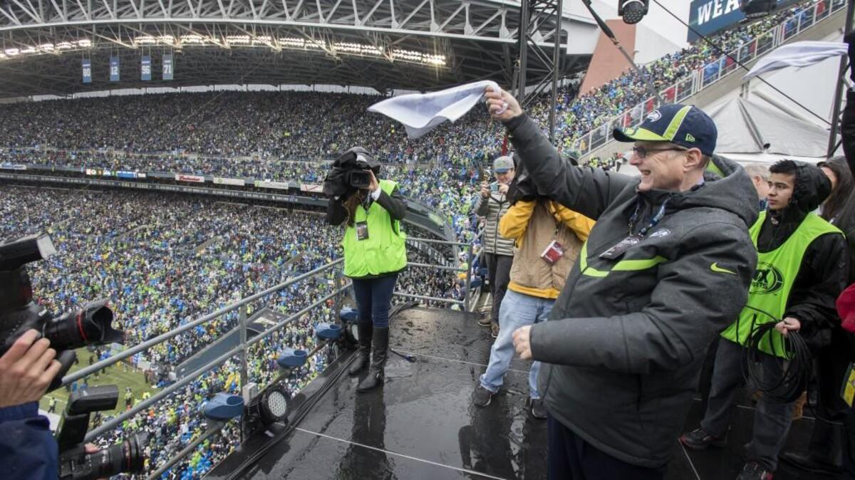 Seahawks owner Paul Allen waves a towel after raising the team's 12th Man flag at CenturyLink Field just before kickoff of the NFC championship game against Green Bay in January 2015. Allen this week pledged $1 million to an initiative for tougher gun laws in Washington.