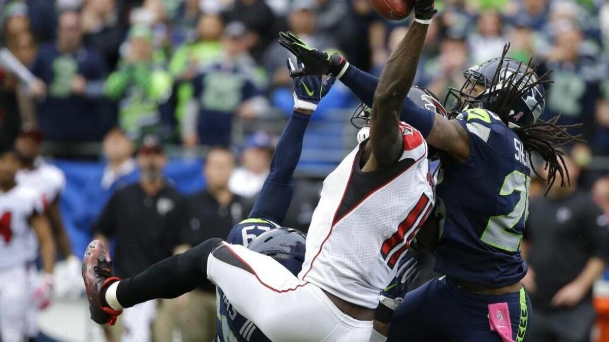 FILE - In this Oct. 16, 2016, file photo, Seattle Seahawks cornerback Richard Sherman, right, and Earl Thomas (obscured) break up a pass intended for Atlanta Falcons wide receiver Julio Jones (11) in the second half of an NFL football game, in Seattle. Jones and the Falcons get another shot at Seattle in Saturday's divisional round playoff game.