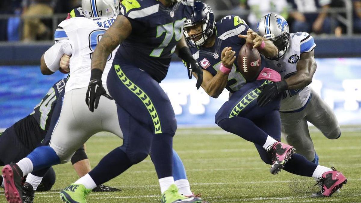 
Seahawks quarterback Russell Wilson fumbles for the second time as he his tackled by Detroit’s James Ihedigbo, right, Monday night in Seattle. The Lions’ Caraun Reid recovered the fumble and returned it for a touchdown.
