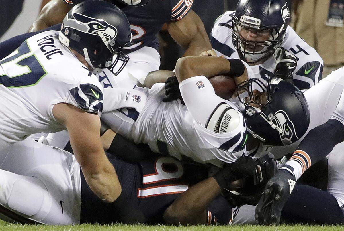 Russell Wilson is sacked for one of his NFL-leading 12 times through two games Monday night, by Bears defensive tackle Eddie Goldman (91) in the first half of the Seahawks’ loss at Chicago. Wednesday, Wilson showed up on the team’s injury report for one of the few times in his career, though he was listed as a full practice participant.