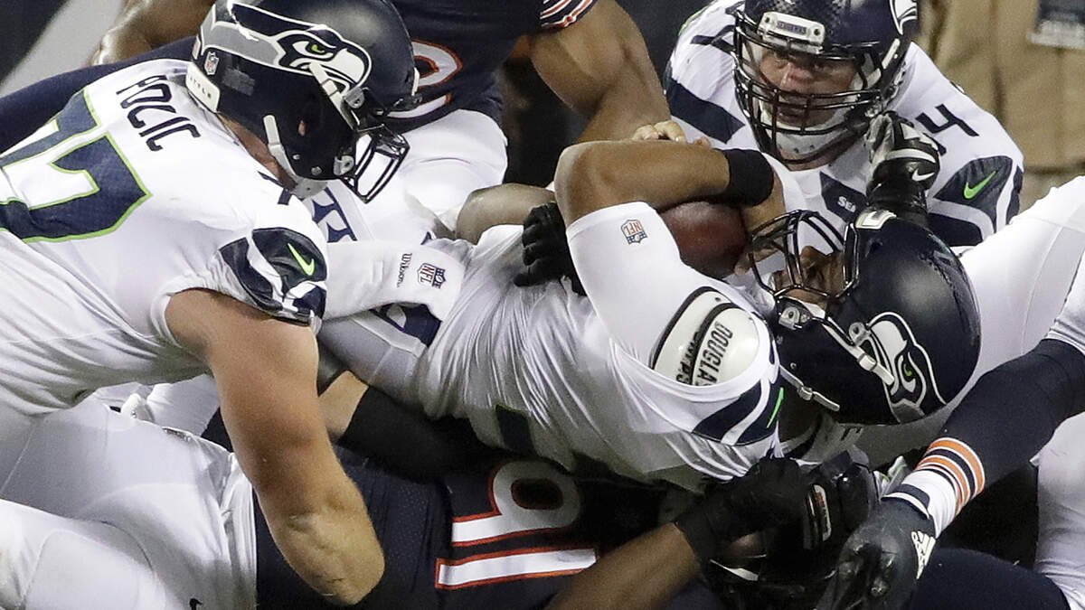 Russell Wilson is sacked for one of his NFL-leading 12 times through two games Monday night, by Bears defensive tackle Eddie Goldman (91) in the first half of the Seahawks’ loss at Chicago. Wednesday, Wilson showed up on the team’s injury report for one of the few times in his career, though he was listed as a full practice participant.