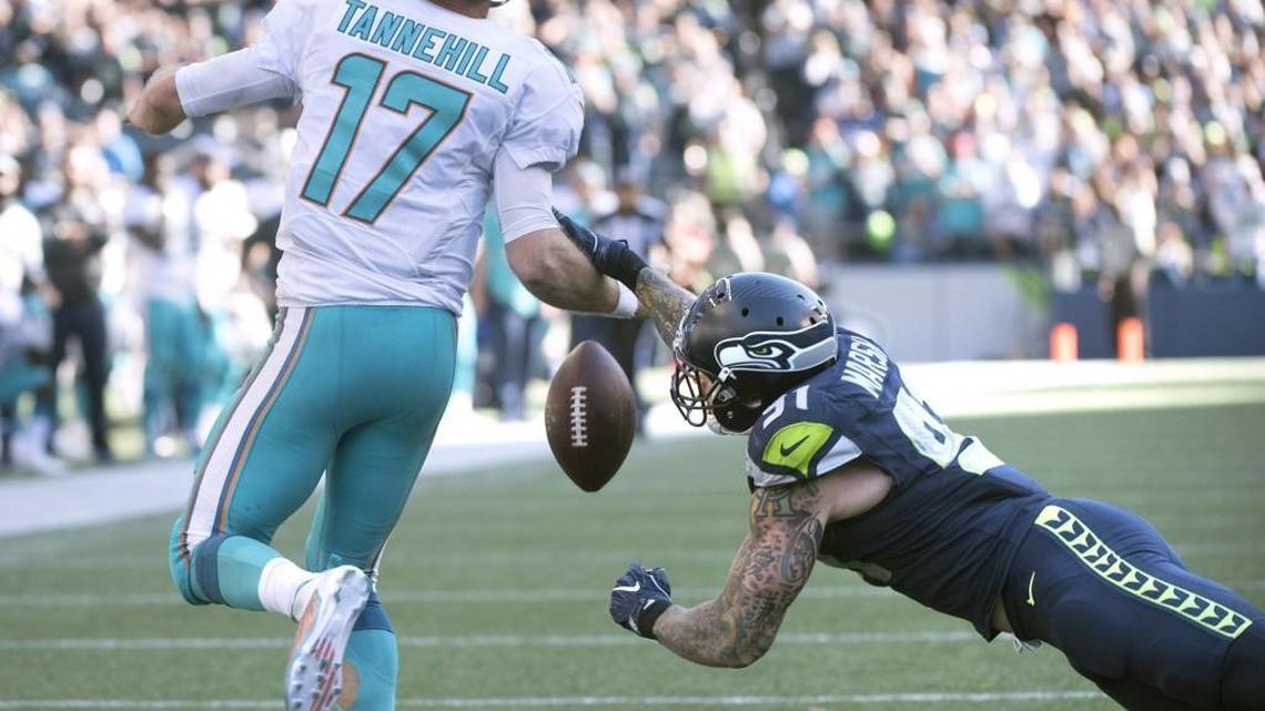 Seattle’s Cassius Marsh, right, knocks the ball loose from Dolphins quarterback Ryan Tannehill en route to a 9-yard sack on Sunday in the game’s closing seconds. Marsh also blocked a 27-yard field goal earlier in the fourth quarter.