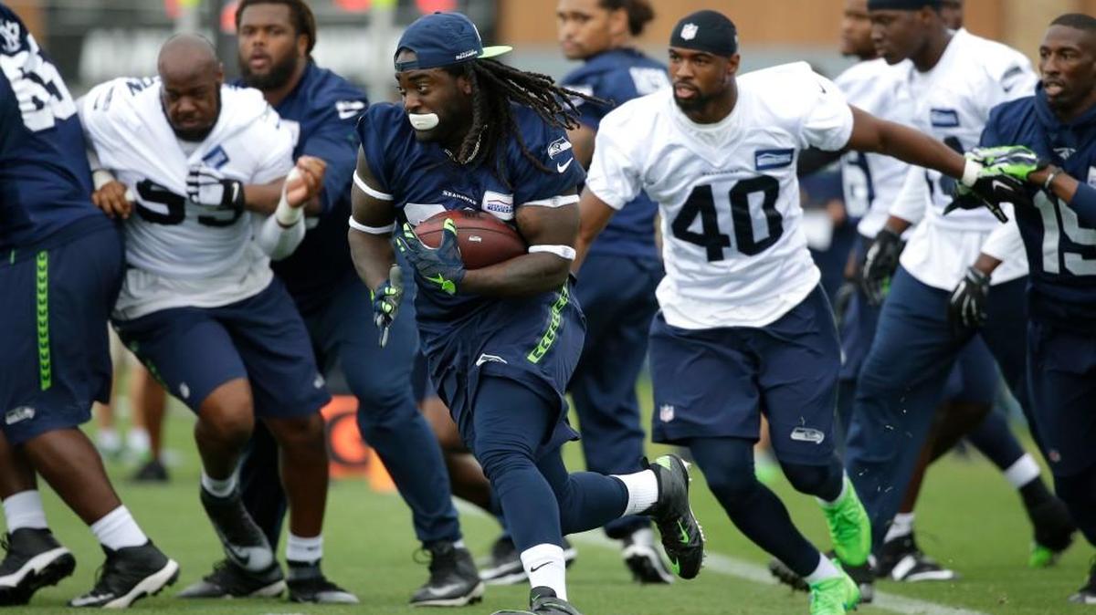 Seattle Seahawks running back Alex Collins, center, carries the ball Saturday during training camp in Renton. Collins scored a running touchdown and a receiving touchdown Sunday to highlight the first game-type scrimmage of training camp.