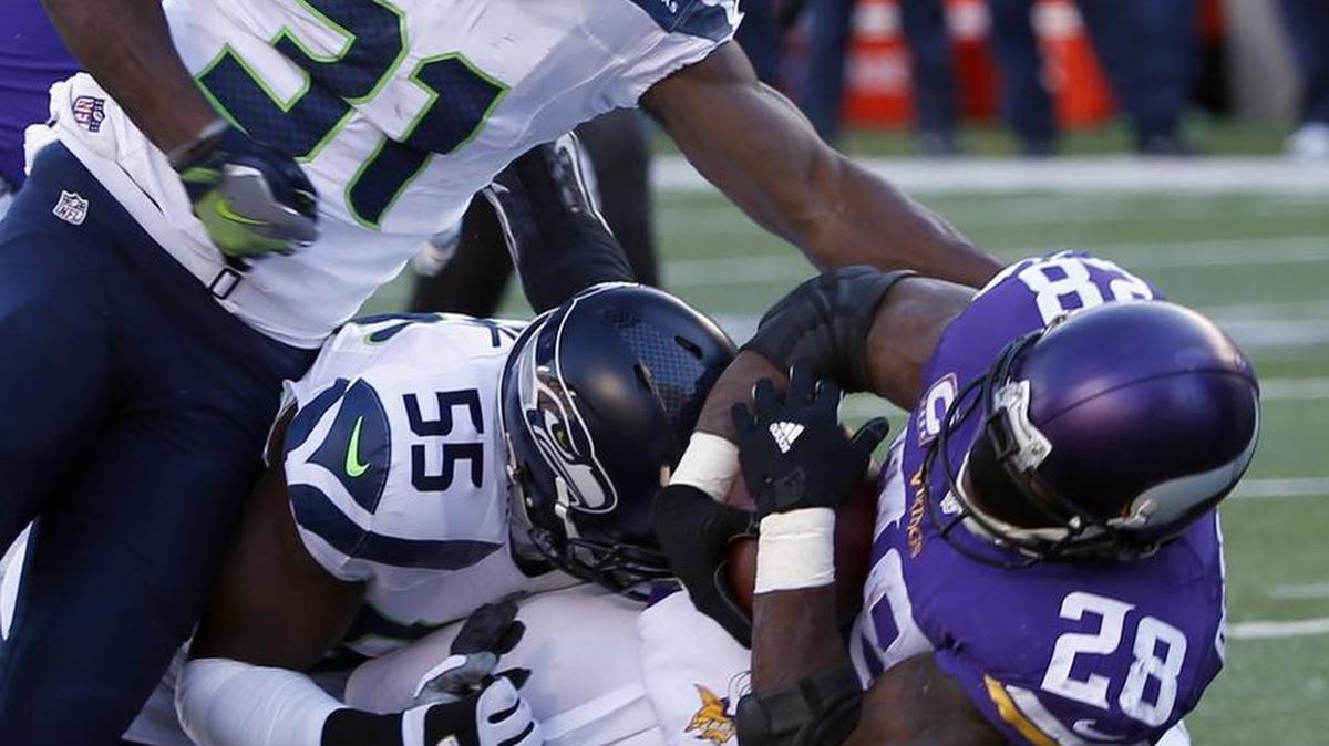 Seattle’s Kam Chancellor (31), Frank Clark (55) and Michael Bennett (72) take down Minnesota’s Adrian Peterson (28). The Seahawks limited Peterson to 45 yards rushing.