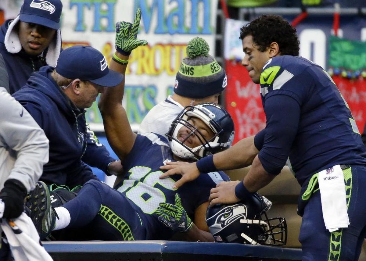 Seahawks quarterback Russell Wilson (right) checks on Tyler Lockett (16), minutes after the wide receiver broke the two main bones in his leg during a game against Arizona in Seattle on Christmas Eve of 2016.
