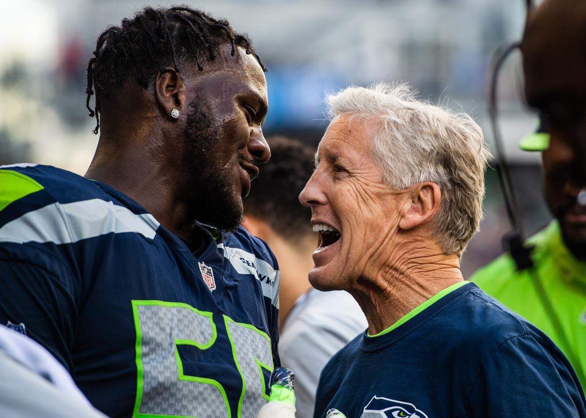 Defensive end Frank Clark (left) and coach Pete Carroll will continue to smile on the Seahawks’ sideline in 2019. Seattle is using its franchise tag for the first time since 2010, to keep Clark from leaving in free agency that begins next week. Monday’s move buys the team four more months to continue working on a long-term extension for its top pass rusher.