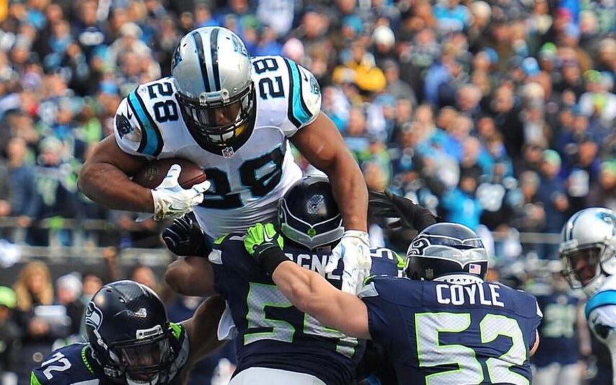 Timberline grad Jonathan Stewart (28) leaps over the Seahawks’ defense to score for the Panthers.