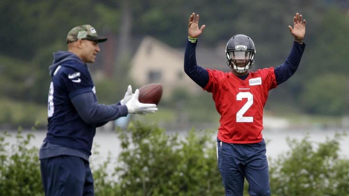 Quarterback Trevone Boykin (2) signals as rehabbing tight end Jimmy Graham catches a ball at a Seahawks spring workout in Renton. The team is preparing for the possibility that Boykin, an undrafted rookie, will be its No. 2 QB this season.