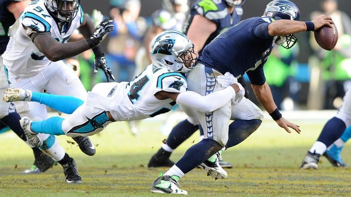Carolina Panthers cornerback Josh Norman (24) tackles Seattle Seahawks quarterback Russell Wilson (3) during the second half of an NFL divisional playoff football game, Sunday, Jan. 17, 2016, in Charlotte, N.C.