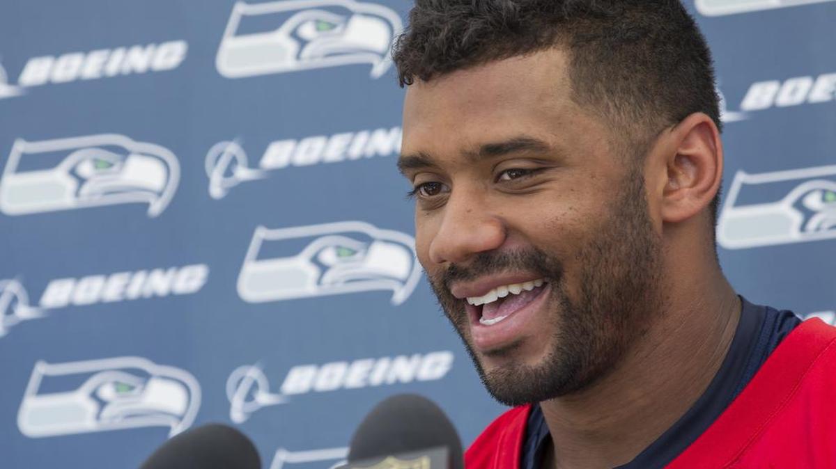 
With his new four-year contract in his pocket, Seattle Seahawks quarterback Russell Wilson speaks at a press conference after training camp on Friday.
