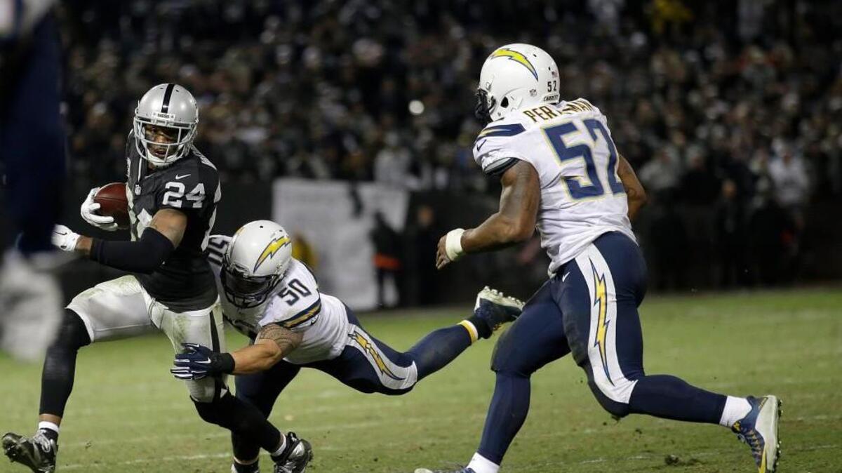 Oakland Raiders' Charles Woodson (24) is tackled by San Diego Chargers inside linebacker Manti Te'o (50) during overtime on Dec. 24.