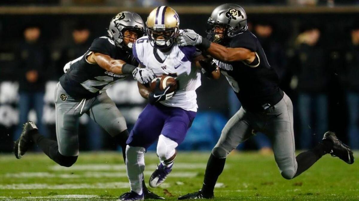 Our annual Seahawks seven-round mock draft predicts the team will take Colorado cornerback Isaiah Oliver, left, tackling Washington wide receiver Chico McClatcher during a game in Boulder last season. Seattle will have to trade to get Oliver in round two; right now the Seahawks don't have a pick in the second nor the third round.