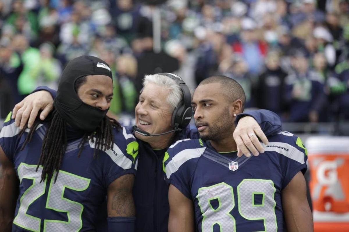 Richard Sherman (25) and former Stanford teammate Doug Baldwin (89) flank coach Pete Carroll during a 2014 game in Seattle. Sherman, now with the San Francisco 49ers, said this week Carroll is “a good man and a good coach” and that he has “no ill will” toward him for how the team released him in March while he was recovering from a torn Achilles tendon. Baldwin said the way it ended for Sherman with the Seahawks was “sh***y.”
