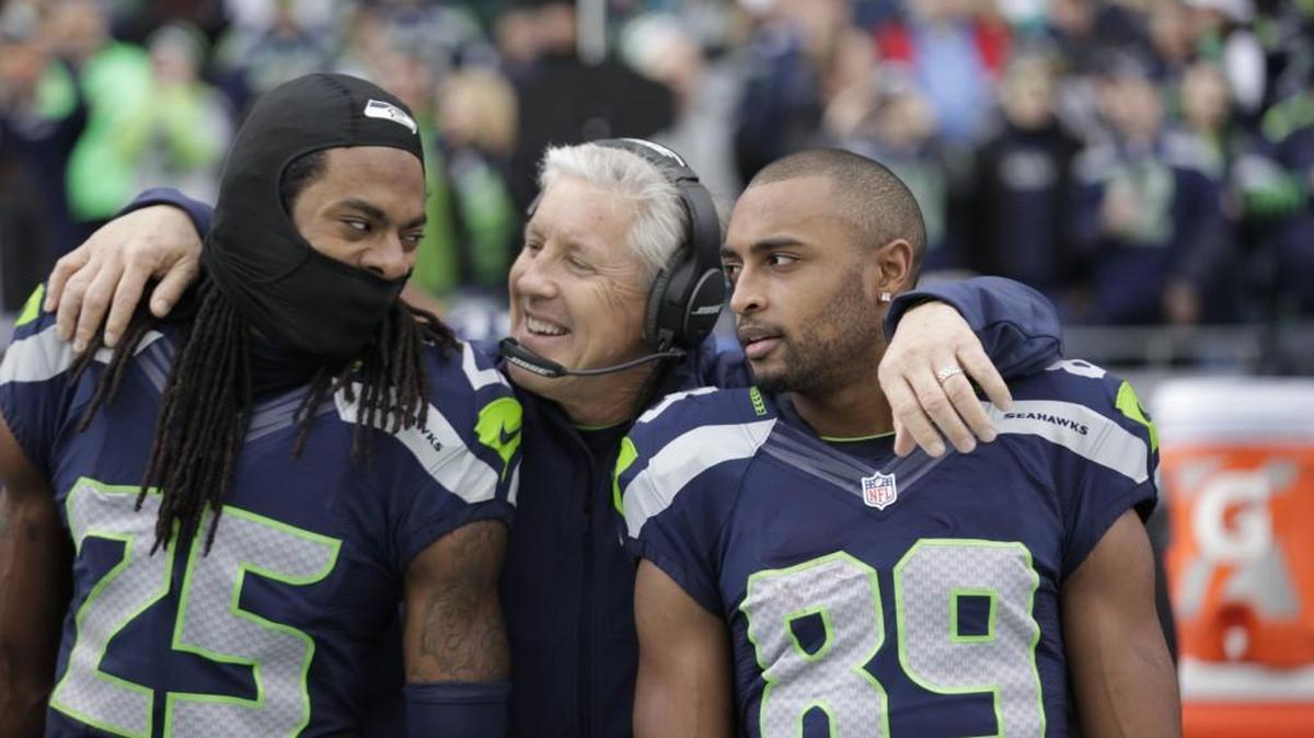 Richard Sherman (25) and former Stanford teammate Doug Baldwin (89) flank coach Pete Carroll during a 2014 game in Seattle. Sherman, now with the San Francisco 49ers, said this week Carroll is “a good man and a good coach” and that he has “no ill will” toward him for how the team released him in March while he was recovering from a torn Achilles tendon. Baldwin said the way it ended for Sherman with the Seahawks was “sh***y.”